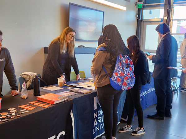 Students talking to a college rep during the college fair