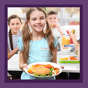 Happy female student holding her school lunch on a plate